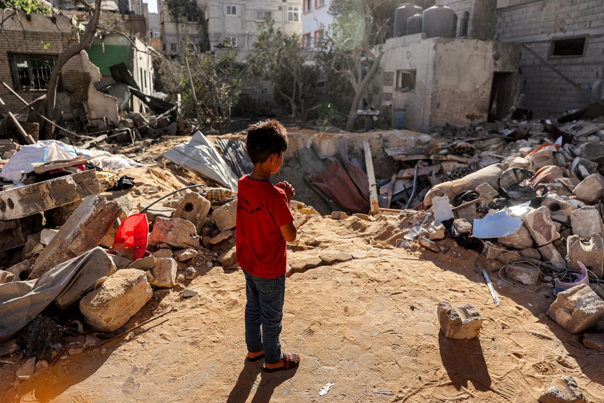 bambini a gaza di fronte alle macerie