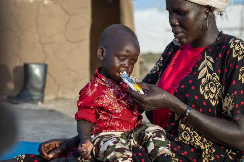 Aker nutre suo figlio Biel, affetto da malnutrizione, con il cibo terapeutico fornito da Save the Children.